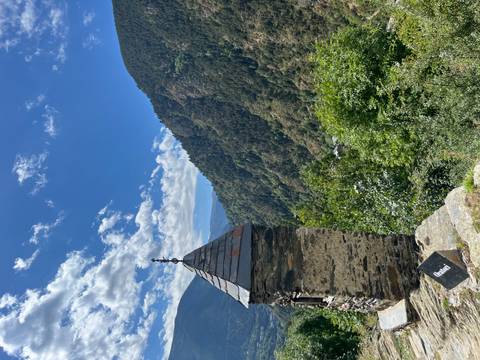       Stone building with mountain views and a sunny sky.
  