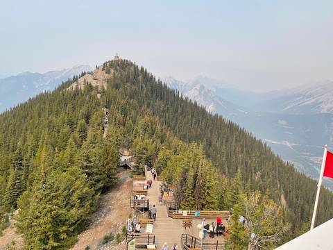 Aerial view of a lush mountain with people hiking on wooden path.