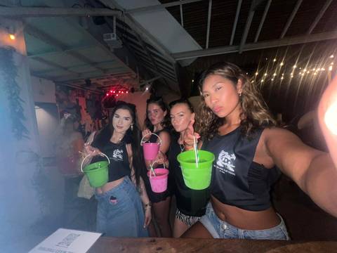 Smiling friends holding colorful buckets at a party.