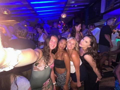 Group selfie at a crowded party or outdoor event.