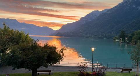      Gorgeous sunset over a lake surrounded by mountains.
  