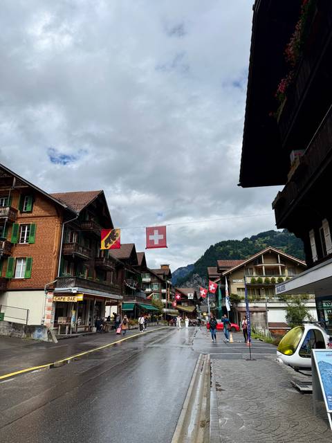       Swiss flags hanging in a village street with alpine backdrop.
  