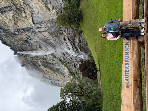       Couple posing in front of waterfall in Lauterbrunnen.
  