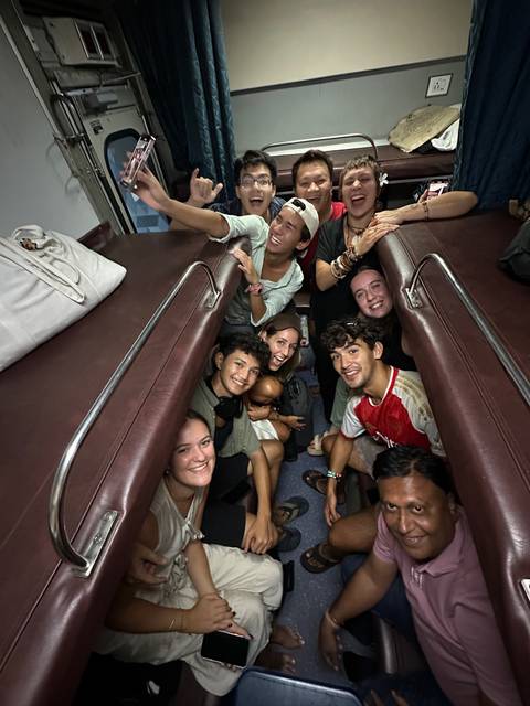       Group of people in a train compartment.
  