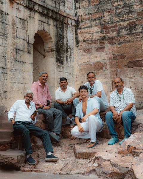       Group of local men sitting at a historical site.
  
