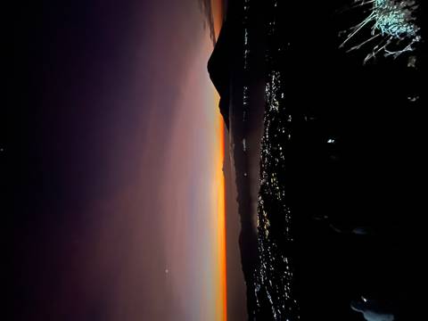 Sunset view from a mountain with lights in the valley.