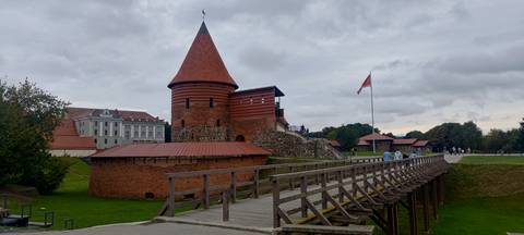 Historic castle with a wooden bridge and a flag.