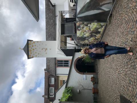 Woman posing in front of a building with a clock tower.