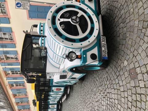 Colorful, small train on cobblestone street.