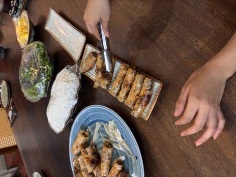 Spring rolls being served on a dish.