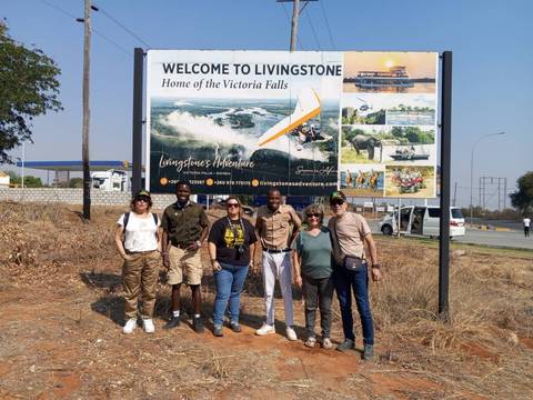 Group photo in front of a welcome sign for Livingstone.