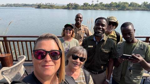Group selfie on a deck overlooking a river.