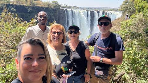 People posing in front of Victoria Falls.