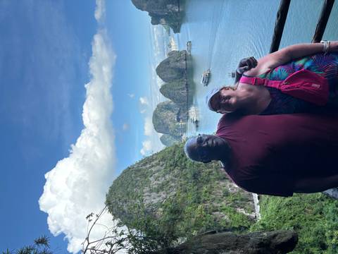       Two people posing with the scenic Halong Bay islands in the background.
  