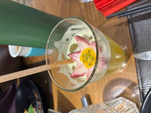       Colorful drink in a glass with an artistic garnish of fruit.
  