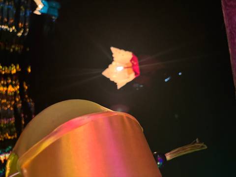       Floating lantern on water during a nighttime festival.
  