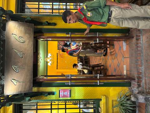       Entrance to a restaurant with vintage decor and a wooden sign.
  