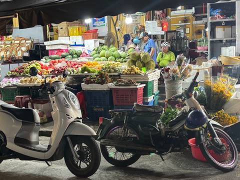 Night market scene with a variety of fruits and vegetables displayed.