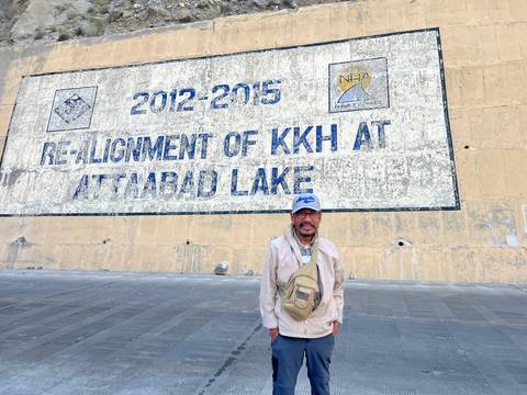 Man standing in front of a wall with historical text.