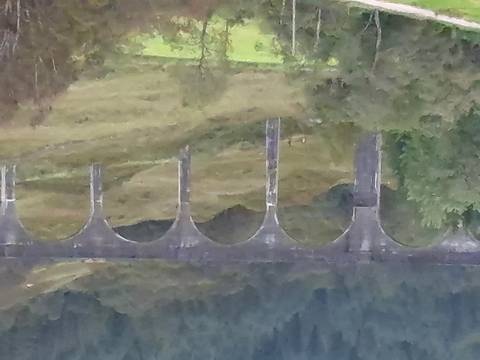 A distant view of a viaduct with arches.