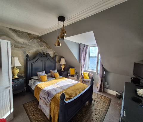 A stylishly decorated room with a bed and window view.