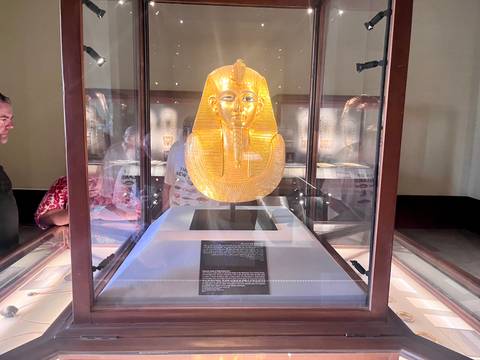 Golden burial mask displayed in a museum.