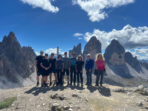       Hiking group standing in front of the Tre Cime di Lavaredo peaks.
  