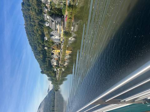 Houses reflecting on a calm river surrounded by hills.