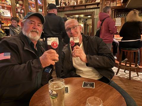 Two men enjoying drinks in an Irish pub.