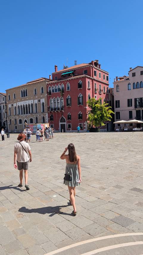 Tourists exploring a charming street square with colorful buildings.