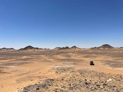       Desert landscape with several distinctive hills.
  