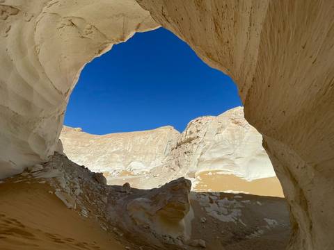 Natural rock archway in a desert landscape.