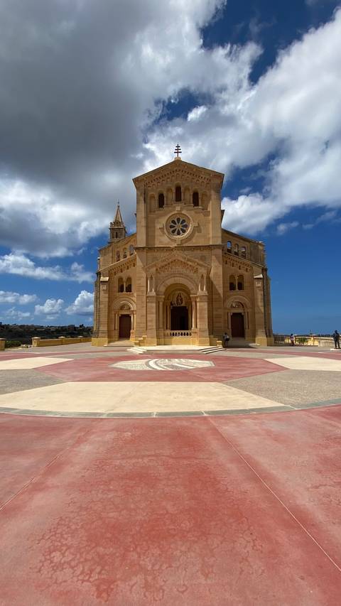 Large stone church with an open plaza in front.
