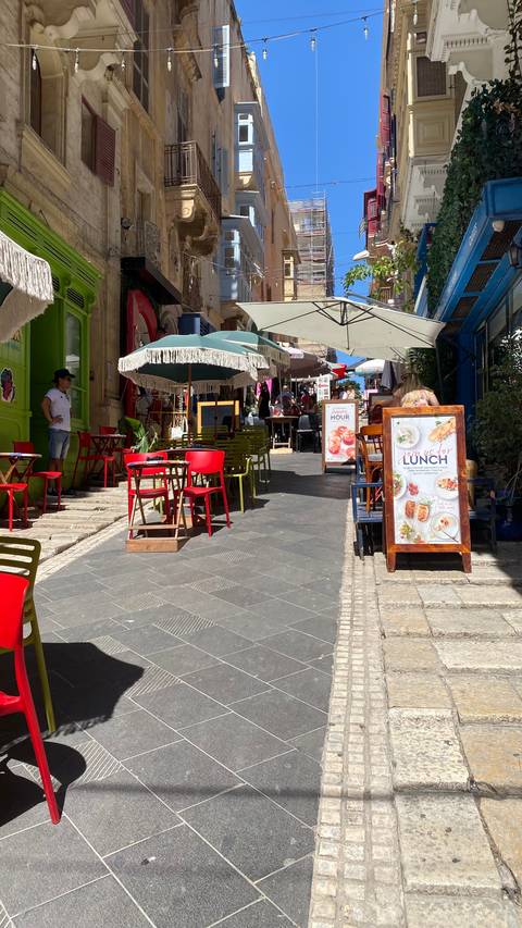 Outdoor cafe with colorful tables and menu boards.
