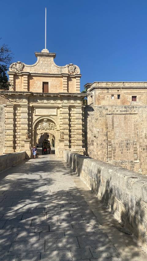 Ornate stone gate with a person walking through.