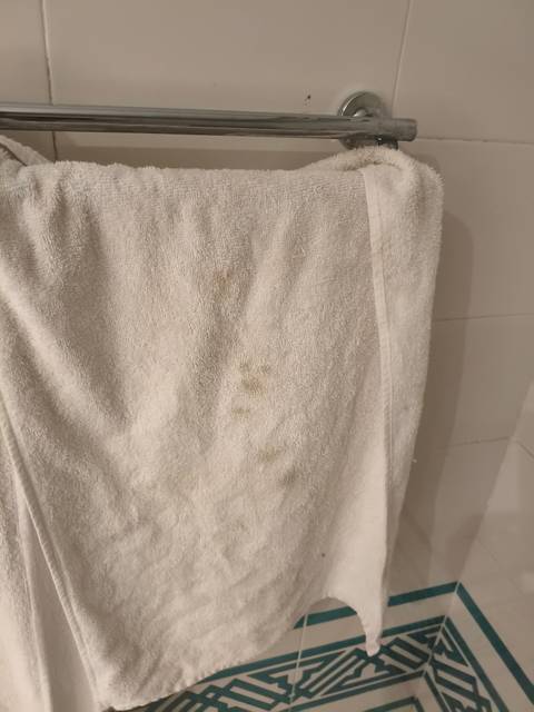 Towel with stains hanging on a rod.