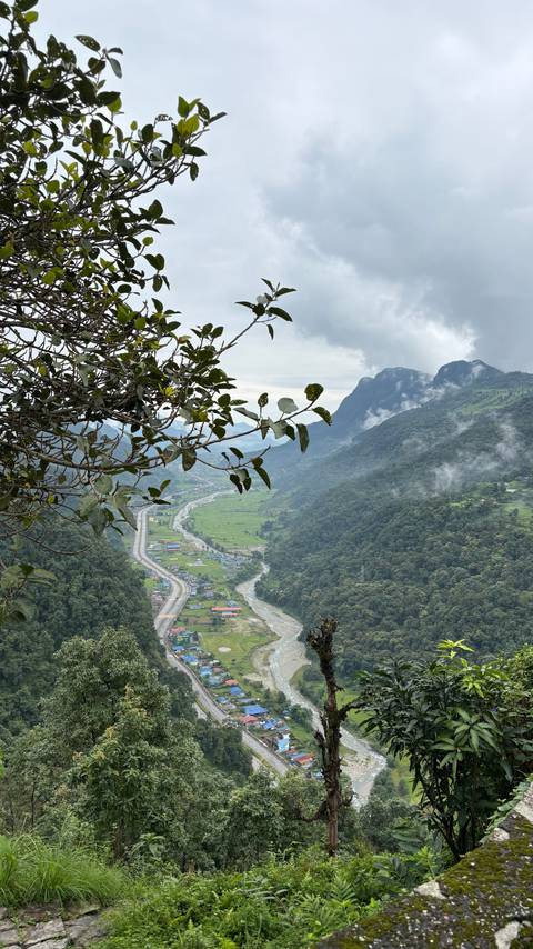 View of a valley with a road, river, and village