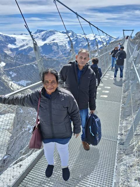 People walking on a suspension bridge in the mountains