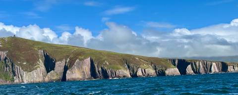       Dramatic cliffs with blue sea and sky.
  