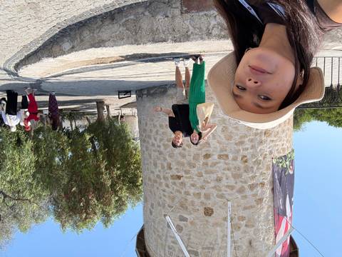 Tourists posing with a stone tower under a clear sky.