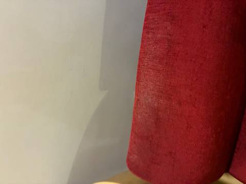 Chair with a red seat against a plain wall.
