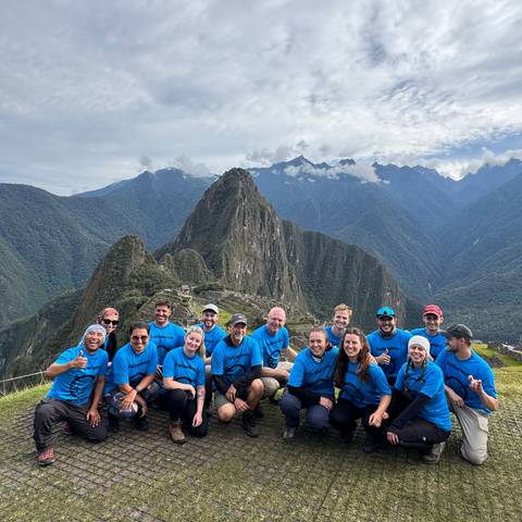 Tour group wearing matching shirts in front of Machu Picchu.
