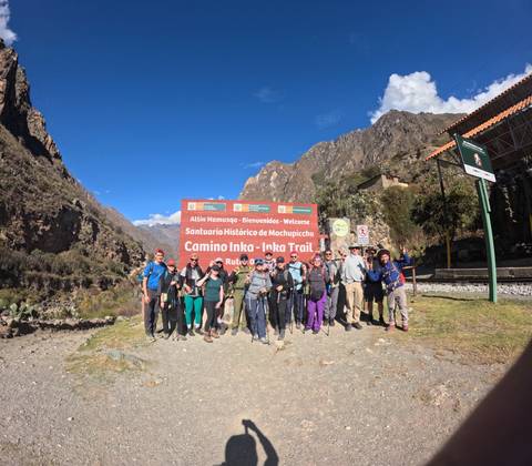 Hikers at Inca Trail entrance, posing enthusiastically.