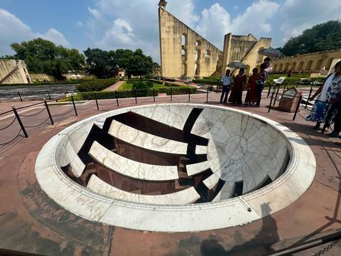       Tourists around a large sundial structure.
  