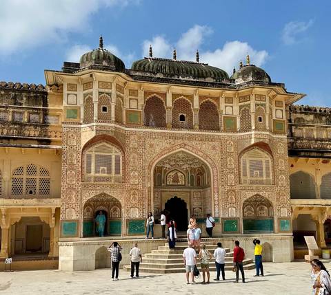       Tourists at the entrance of a lavishly decorated fort.
  