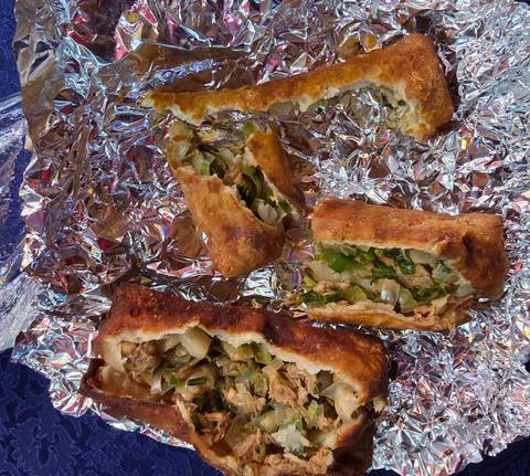 Pieces of a stuffed pastry on foil.