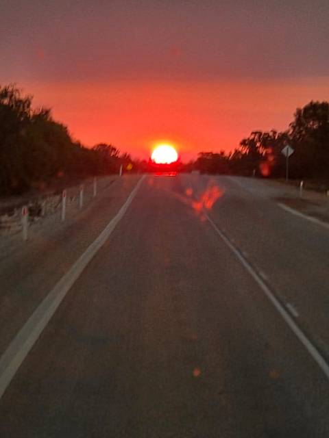Blurry image of a sunset over a road.