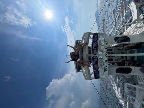 Two people on top of a boat enjoying the view of the open sea.