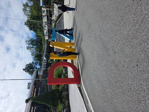Visitors near colorful DMZ sign with a cannon in the background.