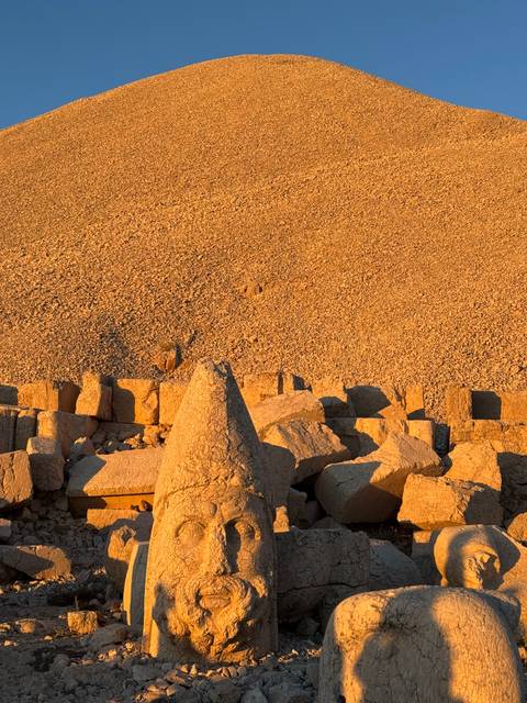       Ruins of ancient stone structures under warm light.
  